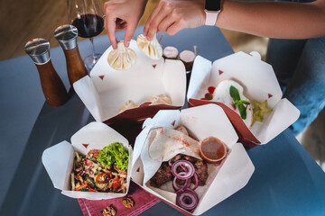 food delivery or cardboard takeaway boxes with salad, meat, dumplings or dessert