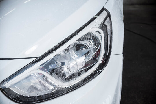 An RFID Tag Sticker On The Headlight Of A Pearl White Car.