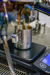 Obraz premium Coffee pours from a coffee machine in a coffee shop for one or two, a beautiful large silver coffee machine is working