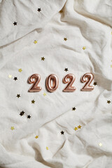 numbers 2022 on grey crumpled textiles. top view new year celebration concept.