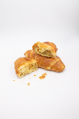 Two fresh juicy croissants with cheese, jam, cream on puff pastry without filling with crumbs on a white background close macro