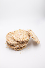 Round bread healthy food from bran, lying on top of each other on a white background, next to crumbs