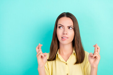 Photo of unhappy millennial brunette lady crossed fingers look empty space wear yellow top isolated...