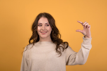 Portrait of a beautiful and attractive Caucasian brunette girl with wavy hair in a casual jumper...