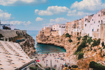 Famous beach of Polignano a Mare in summer day with sky with white clouds