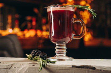 Blackberry mulled wine with rosemary in a glass cup