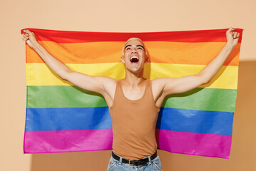 Young activist overjoyed excited fun blond latin gay man with make up in beige tank shirt hold...