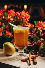 Hot drink cocktail for New Year, Christmas, winter or autumn holidays. Toddy. Mulled pear cider or spiced tea or grog with pear and cinnamon