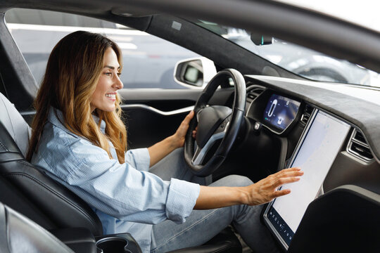 Side profile view caucasian happy smiling confident satisfied woman drive hold put hand on steering wheel look at maps on tablet sitting in auto new car automobile Journey traveling lifestyle concept.