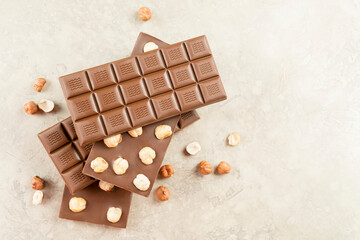 Assortment of Milk chocolate bar with whole hazelnut kernels on white background. Healthy food concept, delicious chocolate sweets for kids, diet, sugar