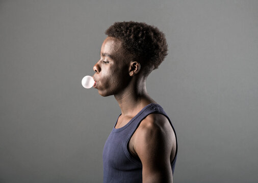 Side View Of A Young Black Man Blowing Chewing Gum