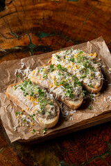 Two forshmak sandwiches on a wooden tray, darks lights soft shadows