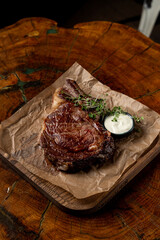 Thick roasted steak with crispy golden crust with garlic sauce, simple but appetizing steak photo on wooden background