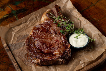 Thick roasted steak with crispy golden crust with garlic sauce, simple but appetizing steak photo on wooden background