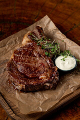 Thick roasted steak with crispy golden crust with garlic sauce, simple but appetizing steak photo on wooden background