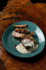Beef steak with baked spicy potato wedges and tartar sauce, small single portion on a bright plate