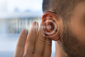 Young man with hearing problems or hearing loss. Hearing test concept. - obrazy, fototapety, plakaty