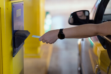 A woman's hand accesses with her security card to open the garage barrier.