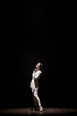 Woman model on stage demonstrates a trouser white suit