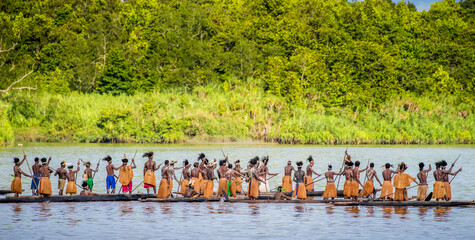 Men Asmat tribe are floating in a canoe on the river. Amanamkay. Village, Asmat province, Indonesia