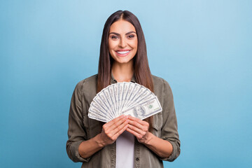 Photo of cute millennial brunette lady hold money wear khaki shirt isolated on blue color background