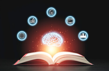 Glowing virtual brain floats above an open book with leaning icons on dark background which is a...
