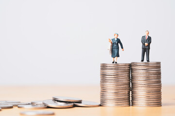 Miniature figure of businessman standing on equal coins stacking of  businesswoman for equality of...