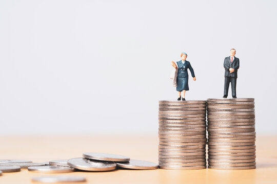 Miniature figure of businessman standing on equal coins stacking of  businesswoman for equality of gender male and female of income and salary concept.