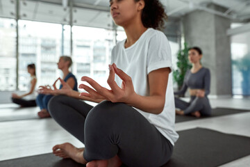 Fototapeta na wymiar Close up of ethnic girl meditate practice yoga at class