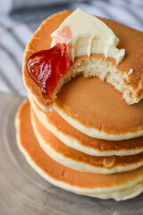 bitten pancakes with butter and strawberry jam