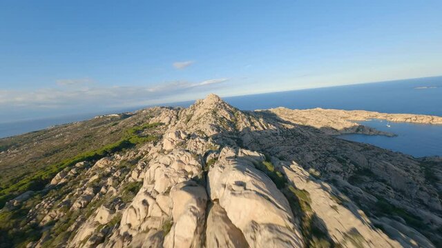 FPV video, mountain surfing, flying at high speed over a granite mountain during a sunny day. Caprera Island, La Maddalena archipelago, Sardinia, Italy.