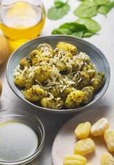 Traditional gnocchi with pesto sauce in gray bowl. It usually prepared with potato and dough