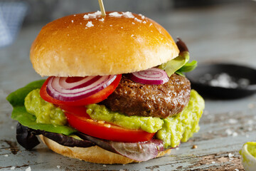 Burger with meat patty and avocado sauce