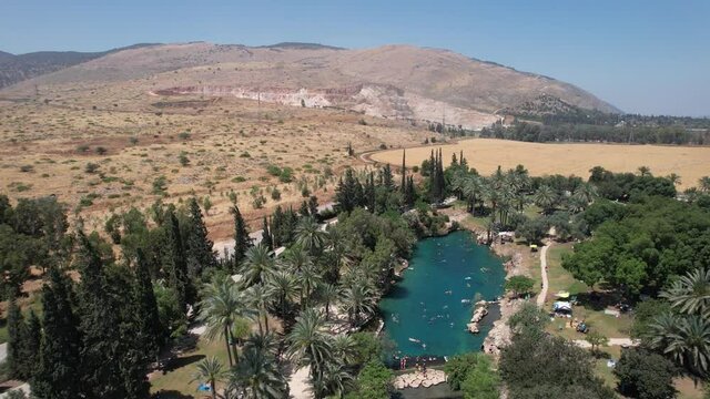 Aerial view around a green lagoon, in Gan HaShlosha National Park, in Israel - orbit, drone shot