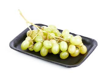 Cluster of green grapes on a black tray on a white background. Healthy food concept