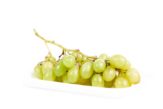 Cluster of green grapes on a white tray on a white background. Healthy food concept