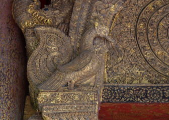 Beautiful ancient gilded wood and stucco carving of mythical swan bird aka hong or hangsa at the entrance of historical viharn Lai Kham, Wat Phra Singh buddhist temple, Chiang Mai, Thailand