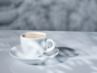 White cup of coffee with natural morning light