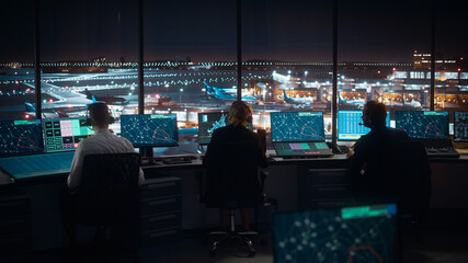 Diverse Air Traffic Control Team Working in a Modern Airport Tower at Night. Office Room is Full of Desktop Computer Displays with Navigation Screens, Airplane Flight Radar Data for Controllers. - obrazy, fototapety, plakaty