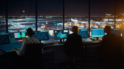 Diverse Air Traffic Control Team Working in Modern Airport Tower at Night. Office Room Full of...