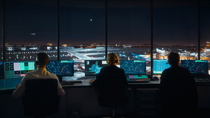 Diverse Air Traffic Control Team Working in Modern Airport Tower at Night. Office Room Full of...