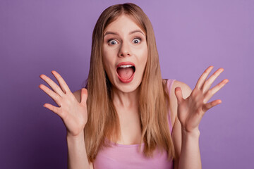 Portrait of excited amazed crazy lady open mouth raise palms have fun wear pink top on violet background