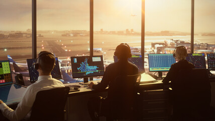 Diverse Air Traffic Control Team Working in Modern Airport Tower at Sunset. Office Room Full of...