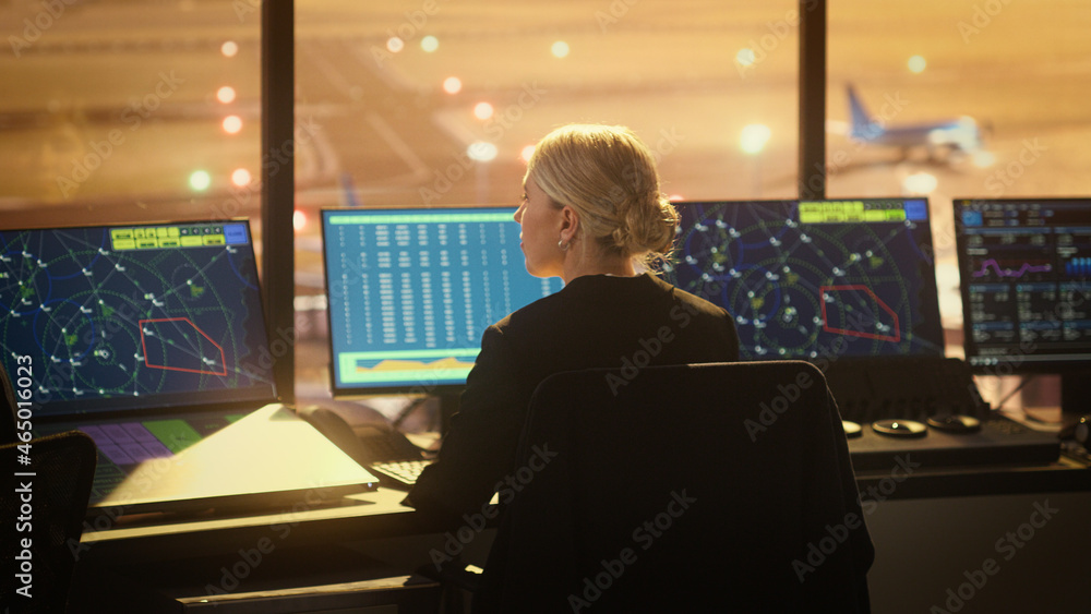 Wall mural portrait of female air traffic controller working in airport tower. office room is full of desktop c