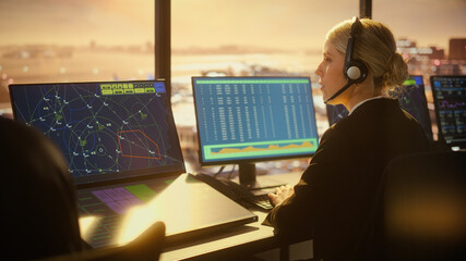 Female Air Traffic Controller with Headsets Talk in Airport Tower. Office Room Full of Desktop...
