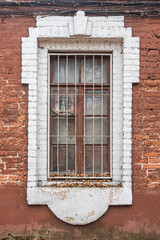 Barred window with brick trim in an old brick house