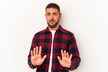 Young caucasian man with diastema isolated on white background rejecting someone showing a gesture...