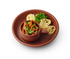 Steamed pepper and eggplant appetizer served with bread slices on clay plate