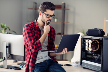 Portrait of attractive minded guy checking server error solving web network problem indoor at work...