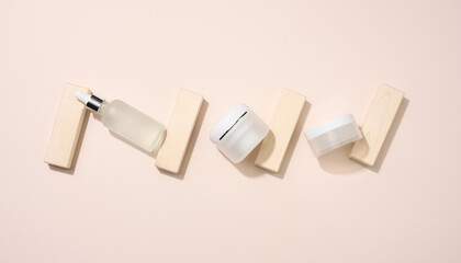 plastic jar and white glass bottle with pipette stands on a beige background. Cosmetics SPA branding. Packaging for gel, serum, advertising and product promotion, mock up